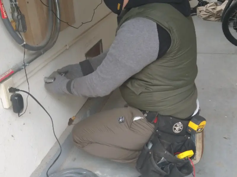 Electrician performing outlet wiring in a Belfast garage